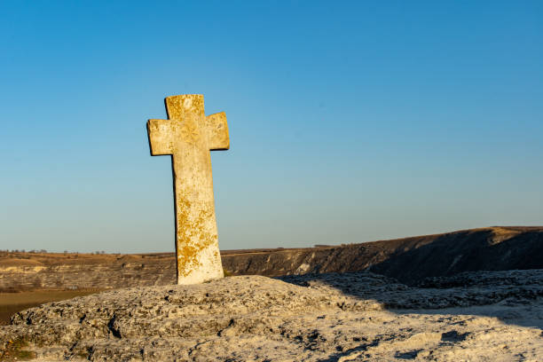 alten orhei stein geschnitzte kreuz vor der alten stein kirche - stone cross stock-fotos und bilder