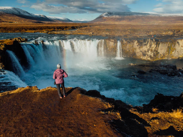 istock Woman looking at waterfall in Iceland 1125607206