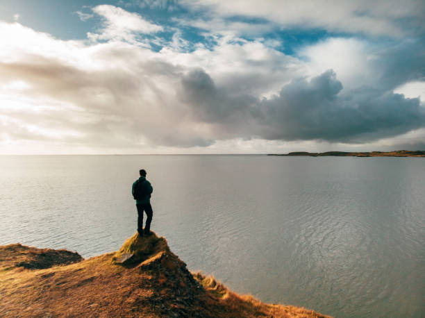istock Man looking and celebrating sunrise and landscape 1125607653