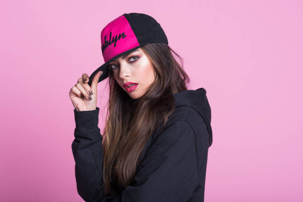 young woman in black hooded shirt against pink background - gangsta rap imagens e fotografias de stock