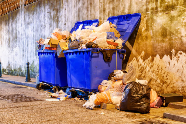 Overflowed garbage bins on the street Overflowed garbage bins. View of trash cans on night street. overflowing dumpster stock pictures, royalty-free photos & images