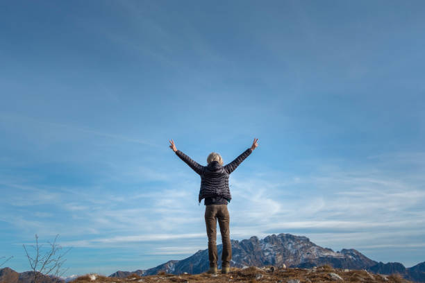 istock Happy woman with arms raised on mountain top 1125613914