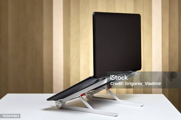 The Laptop Is Open And Mounted On A Cooling Stand Stock Photo - Download Image Now - Laptop, Standing, Bracket - Household Fixture