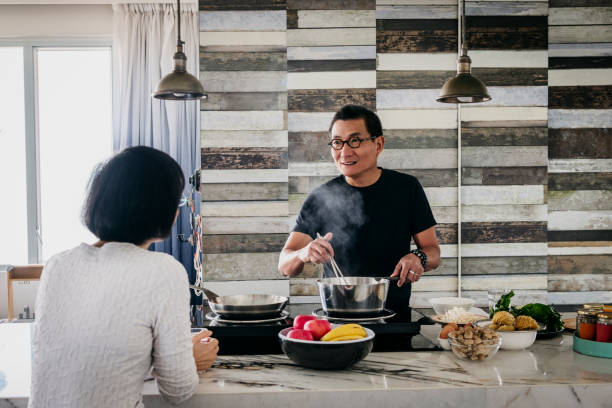 istock Mature Chinese man preparing dinner in kitchen with woman 1125619221