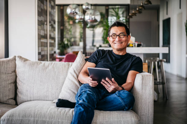 istock Cheerful mature Chinese man with tablet smiling 1125619255