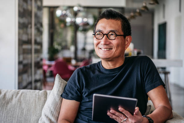istock Cheerful mature man with tablet smiling and looking away 1125619290
