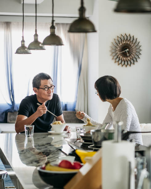 istock Chinese couple sitting at dining table and eating lunch 1125619301