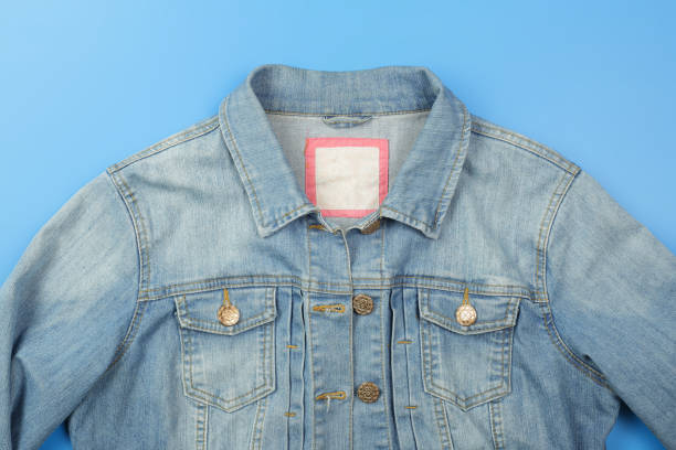 istock Clothes, shoes and accessories - top view fragment blue jeans jacket empty label blue background 1125621306
