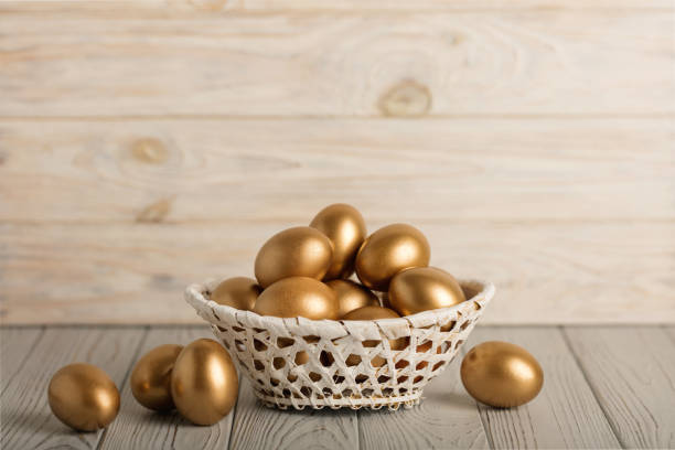 istock Happy easter! Easter eggs of golden color on a light wooden background. 1125623033