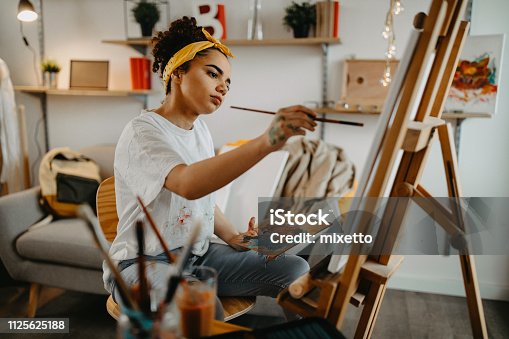 istock Girl painting on canvas 1125625188
