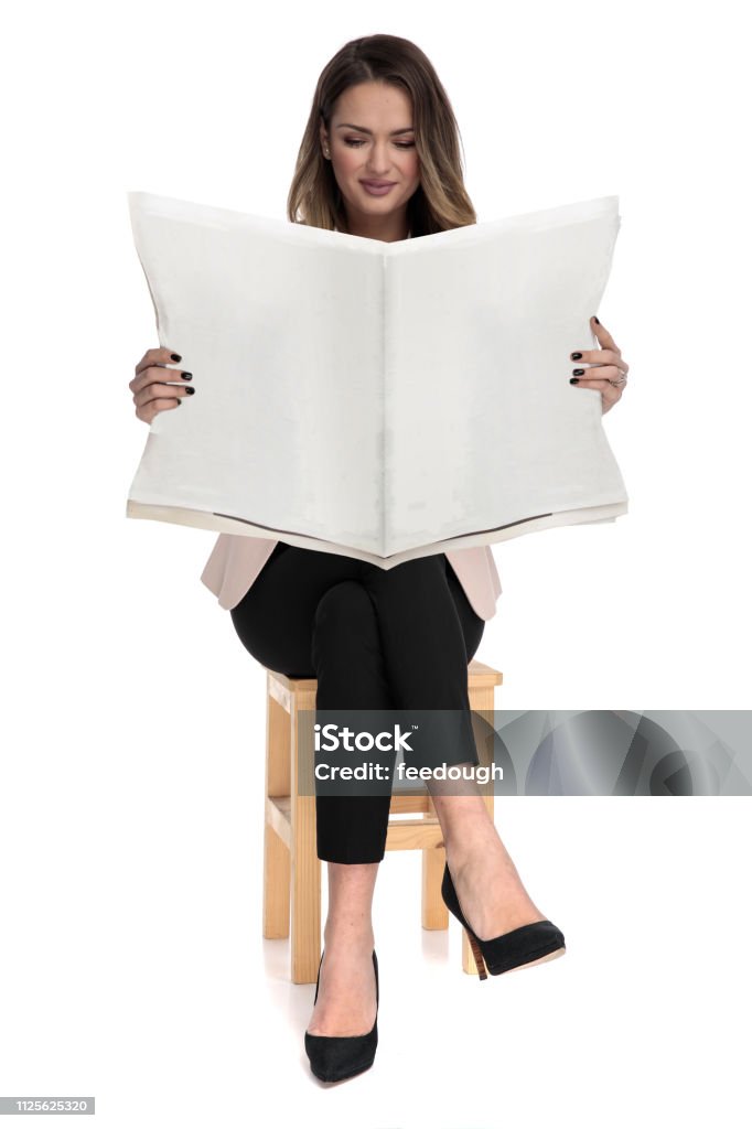 businesswoman relaxing on wooden chair reads the newspaper businesswoman sitting on wooden chair on white background with legs crossed reads the newspaper, on white background Newspaper Stock Photo