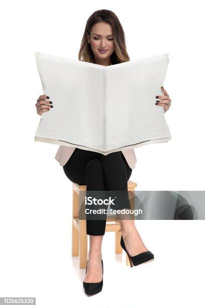 Businesswoman Relaxing On Wooden Chair Reads The Newspaper Stock Photo - Download Image Now