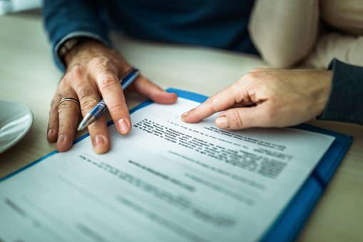 Close up of signing a mortgage contract in the office.