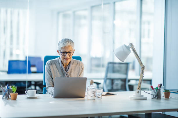 istock Smiling senior entrepreneur working on laptop in the office. 1125630124
