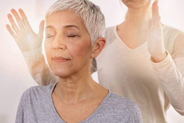 woman having reiki healing treatment , alternative medicine concept, holistic care - naturopath imagens e fotografias de stock