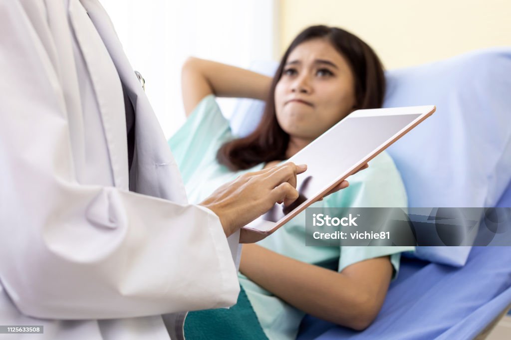 Patient fell worry Patient fell worry when Asian Doctor make routine health check in hospital ward Breast Stock Photo