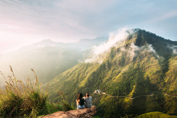 das paar grüßt den sonnenaufgang in den bergen. mann und frau in den bergen. hochzeitsreise. das paar reist durch asien. reise nach sri lanka. serpentine in den bergen. menschen grüßen die dämmerung - sri lanka stock-fotos und bilder