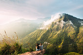 The couple greets the sunrise in the mountains. Man and woman in the mountains. Wedding travel. The couple travels around Asia. Travel to Sri Lanka. Serpentine in the mountains. People greet the dawn