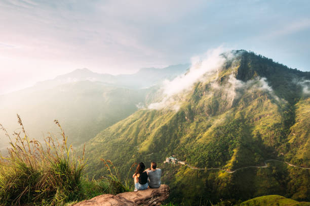 The couple greets the sunrise in the mountains. Man and woman in the mountains. Wedding travel. The couple travels around Asia. Travel to Sri Lanka. Serpentine in the mountains. People greet the dawn stock photo