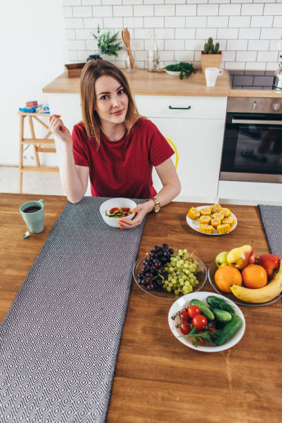 ホーム食べる果物や野菜トップ ビューで女性。 - model home house home interior plate ストックフォトと画像