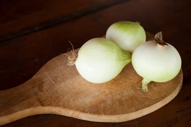 zwiebel auf schneidebrett - sweet onion stock-fotos und bilder