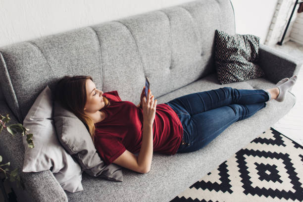 istock Woman lying on the sofa and using smartphone at home 1125636997