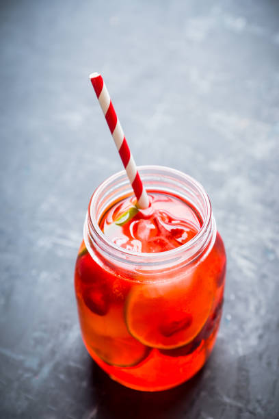 istock Red cocktail with cherry and lime in jar on the rustic background 1125637176