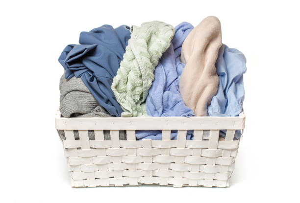 istock Clothes in a laundry wooden basket isolated on white background 1125637377
