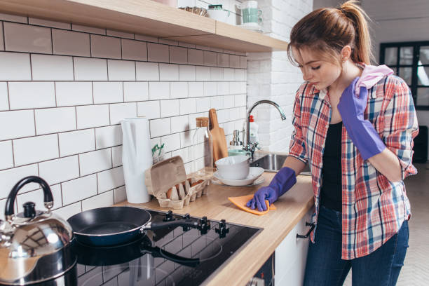 若い女性が台所でテーブルを拭きます。 - cleaning domestic kitchen counter top housework ストックフォトと画像