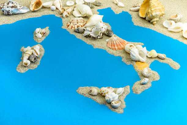 Map of Italy and islands in the Mediterranean from sand. on top are seashells.