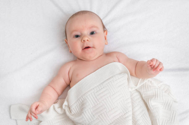 istock Newborn baby is lying on back on white blanket 1125639035