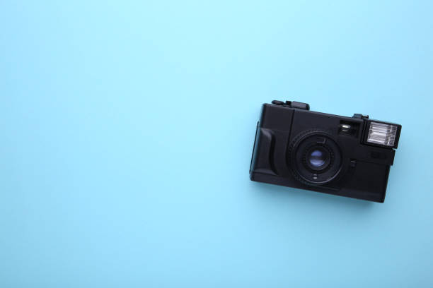 istock Vintage camera on blue background. Old photo camera on background 1125639181