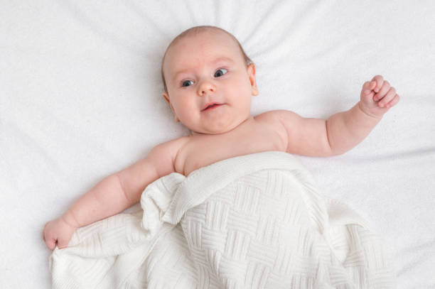 istock Newborn baby is lying on back on white blanket 1125640469