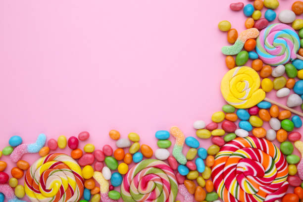 istock Colorful lollipops and different colored round candy on pink background 1125640817
