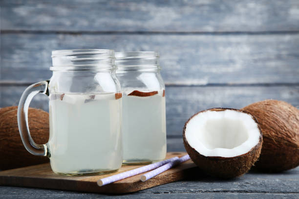istock Coconut water in jars with straws on wooden table 1125643493