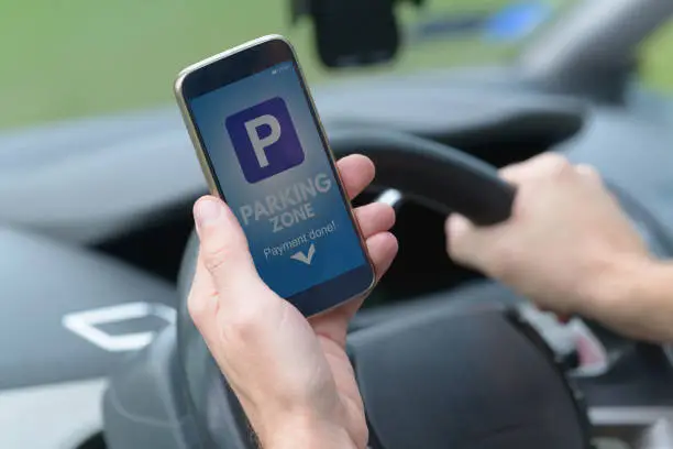 Photo of Driver using smartphone app to pay for parking