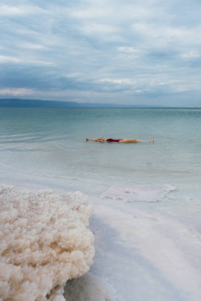 istock Woman floating on water  in Dead Sea 1125650498