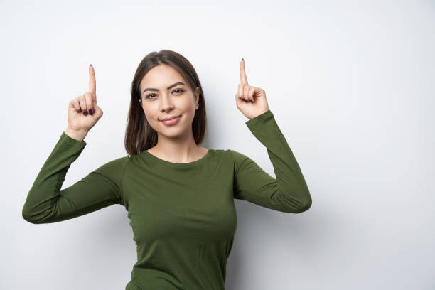 istock Happy woman pointing up with two fingers 1125651367