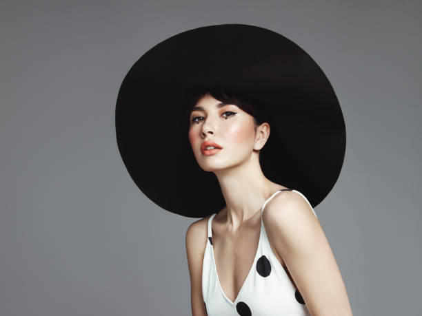 Beautiful elegant woman with oversized hat Studio portrait of elegant woman wearing big black hat huge black woman pictures stock pictures, royalty-free photos & images