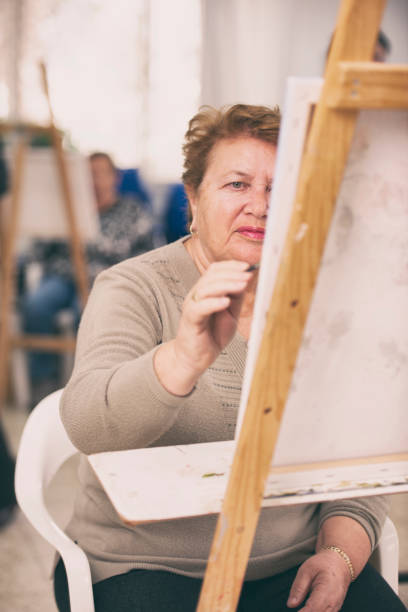 istock Mature woman drawing on canvas. 1125655997