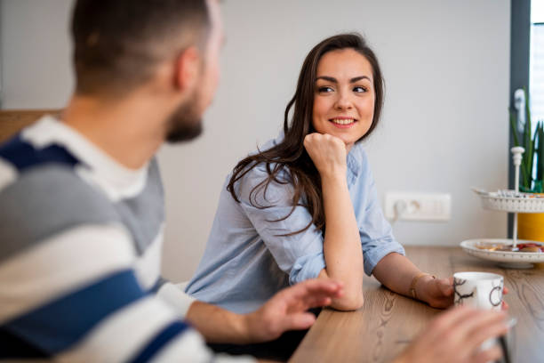 istock Young couple sitting in the kitchen and drinking tea 1125657692