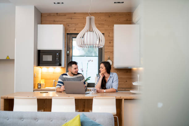 istock Young couple sitting in the kitchen and drinking tea 1125657950