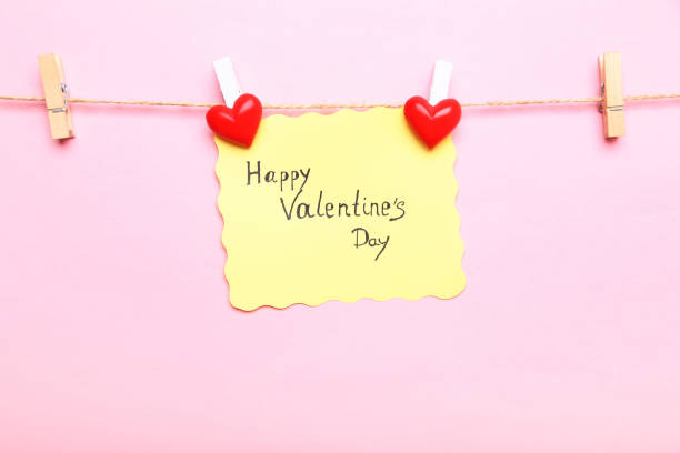 istock Paper with text Happy Valentine Day hanging on pink background 1125659208