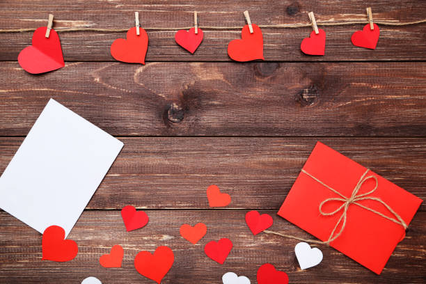 istock Paper hearts with envelope on brown wooden table 1125659730