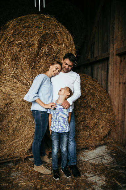istock Happy family with son standing in barn 1125659783