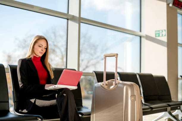 istock Young woman using a laptop in an airport 1125659988