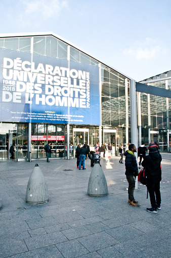 Travelers, commuters and tourists outside SNCF Gare du Nord train station carrying a banner in Paris, Île-de-France. The banner celebrates the 70th anniversary of the United Nations Universal Declaration of Human Rights