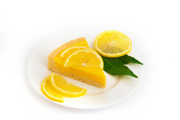 Fresh delicious lemon cheesecake and sliced lemon fruit on white plate