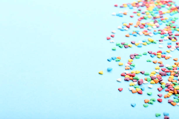istock Colorful heart shaped sprinkles on blue background 1125661009