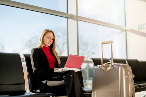 istock Young woman using a laptop in an airport 1125661408